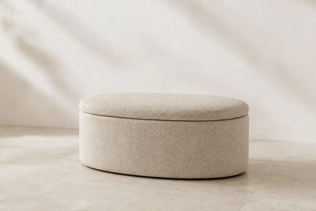 Synthetic demo image: oat-colored Pebble oval ottoman in a neutral studio.